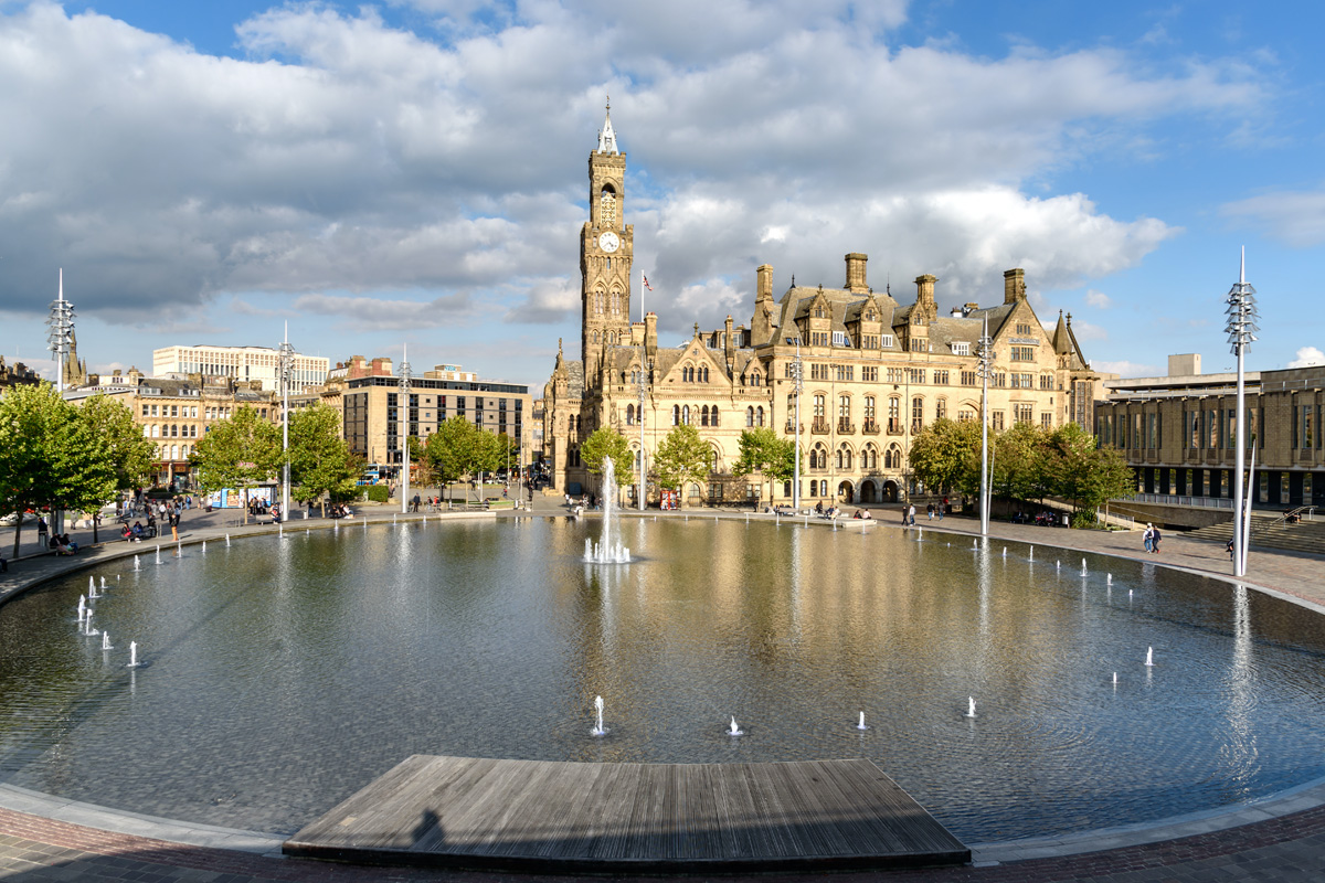 The City Park Mirror Pool in Bradford, West Yorkshire. A fountain sits before Bradford's municipal buildings.