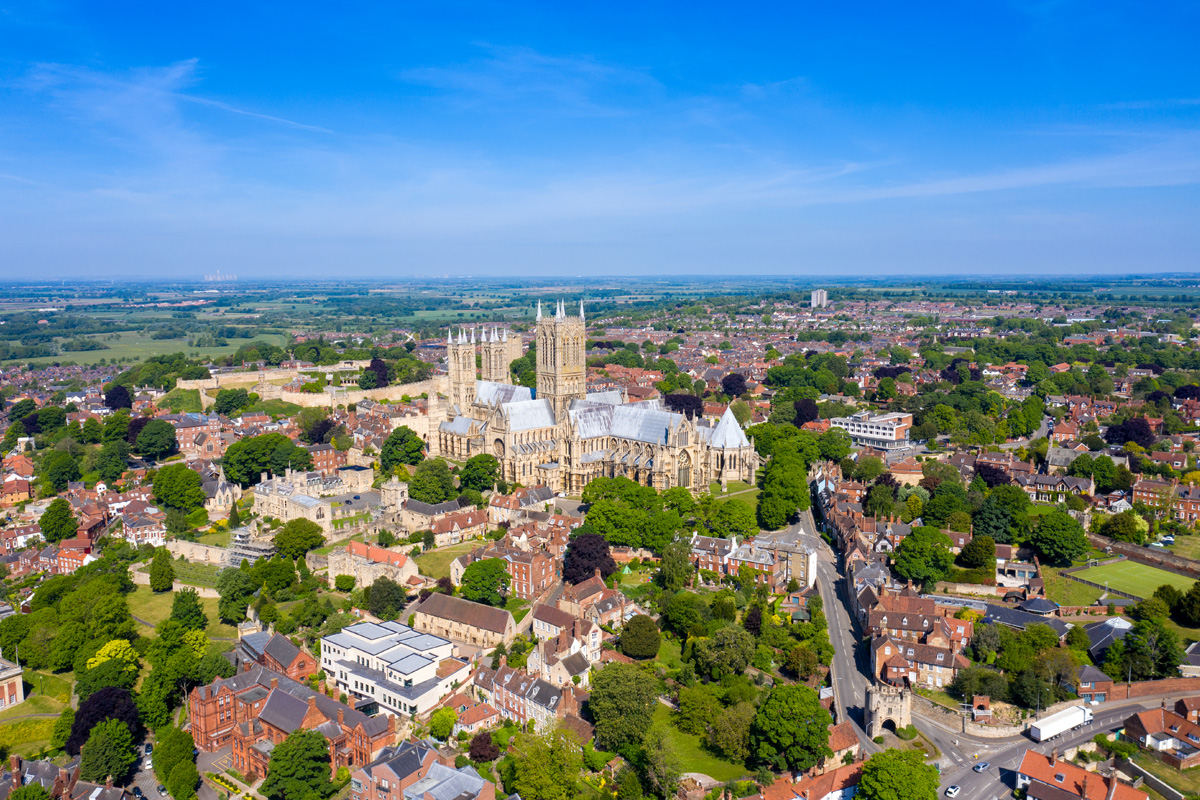 An aerial photograph of Lincoln city centre with Lincoln Cathedral and Lincoln Minster in view. Photograph taken by a drone on a bright, summer day.