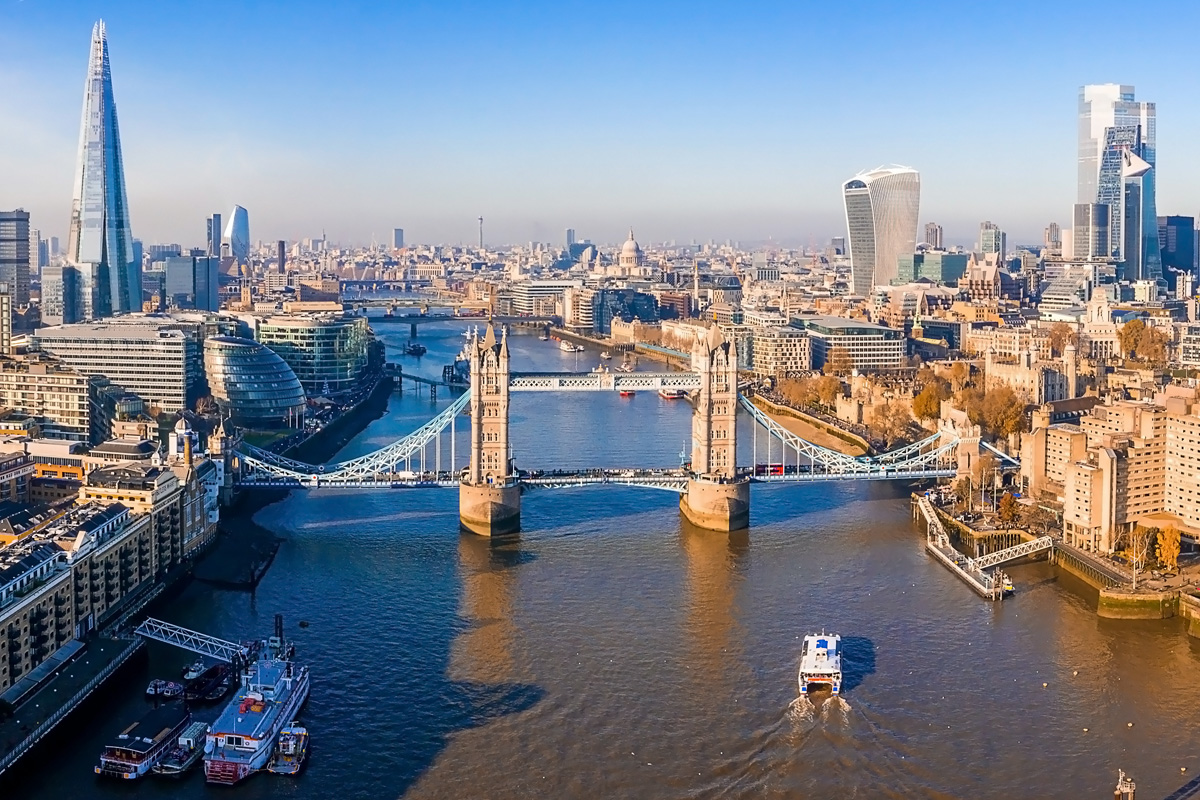 An aerial view of London and the Thames, with Tower Bridge in the middle. Other visible, famous landmarks include The Shard and The Walkie-Talkie (20 Fenchurch Street).