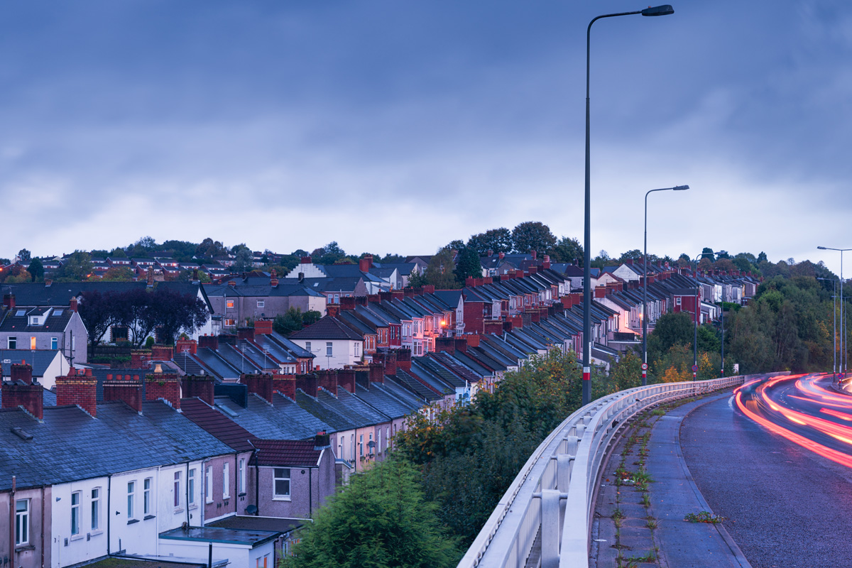 A typical UK housing estate sits next to a major road in the early morning. Photograph taken in the city of Newport in South Wales.